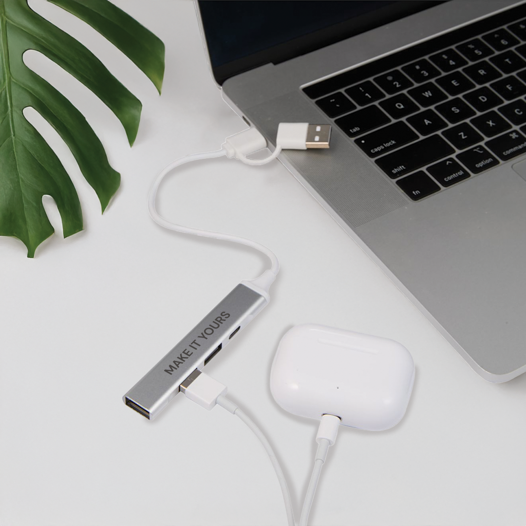 USB hub plugged into laptop resting on white table