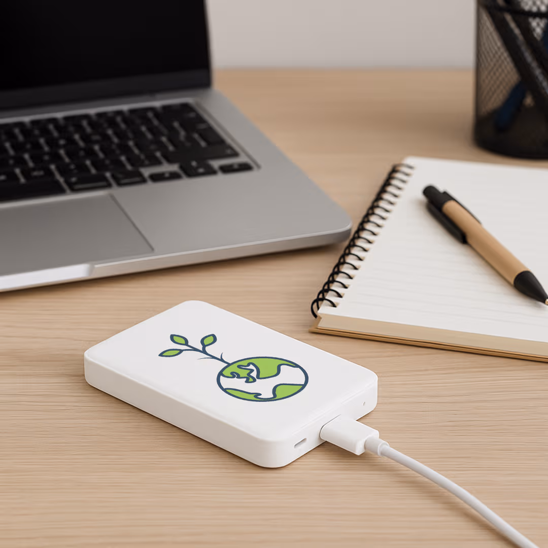 portable charger resting on desk beside notebook and laptop