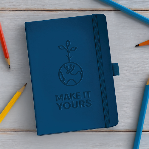 notebook laying on wooden table surrounded by pencils