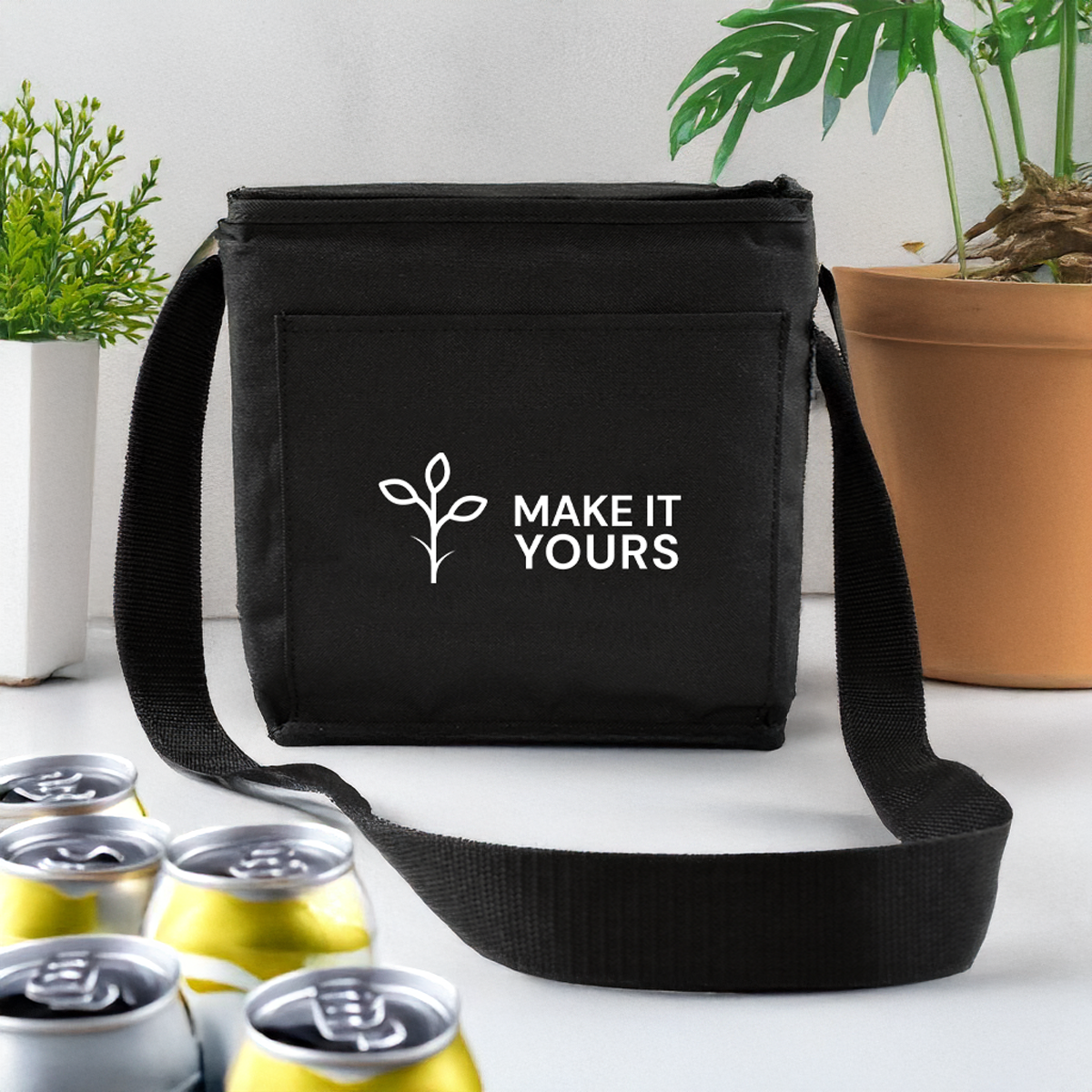black can cooler resting on white counter beside cans and potted plant