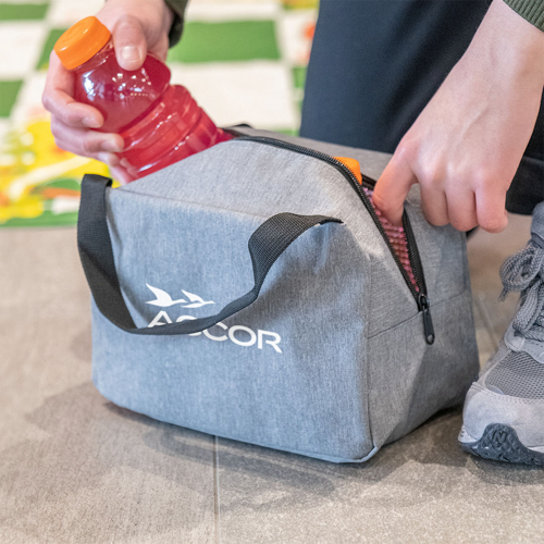 cooler bag on ground with man pulling sports drink out of it