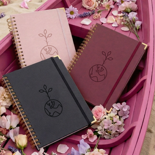 three notebooks surrounded by flower petals