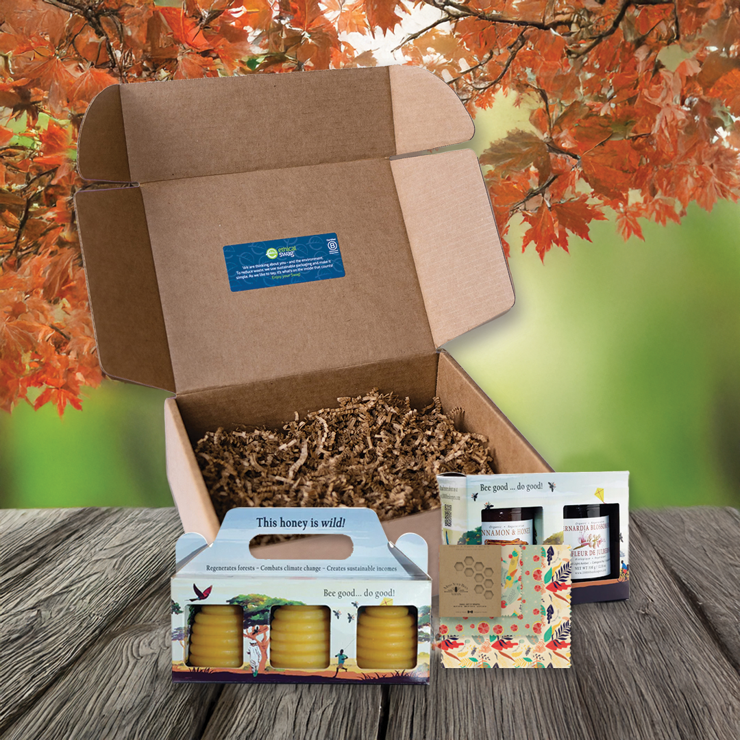 swag pack resting on picnic table in fall, containing beeswax candles, honey, and beeswax food wraps
