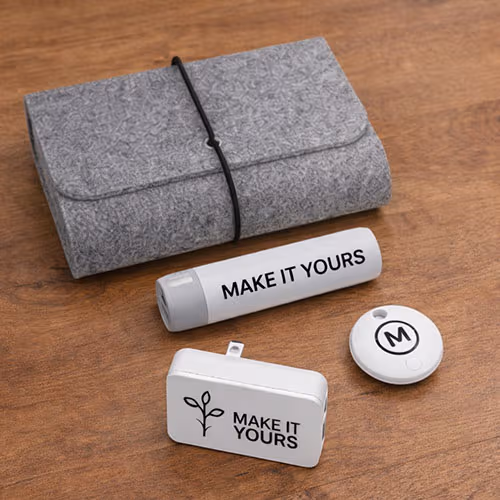a grey travel kit that contains a portable power bank, dual-port travel plug, and bluetooth tracking device