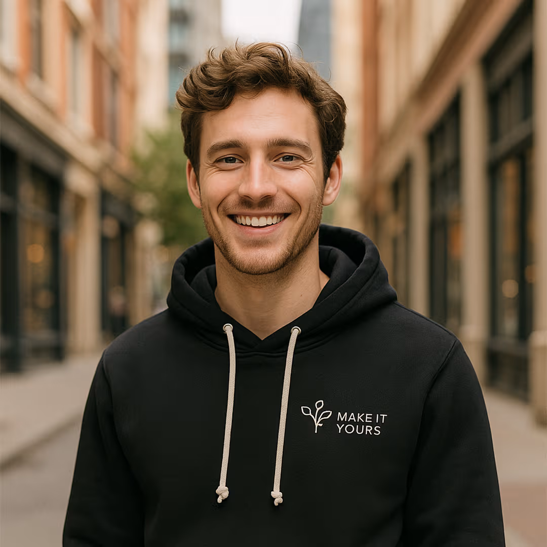 man wearing black custom branded hoodie and smiling in urban setting