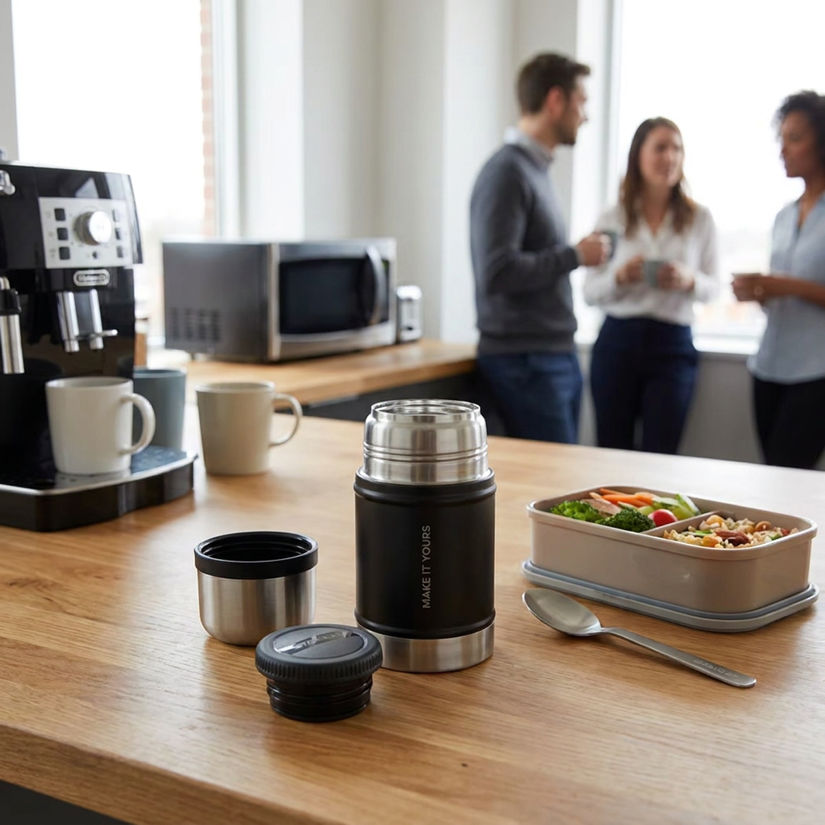 branded travel food jar sitting on breakroom table beside packed lunch with coworkers chatting in the background