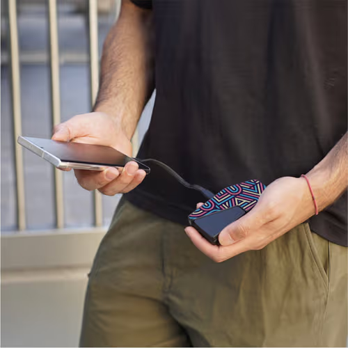 man holding custom powerbank in left hand with his phone in the right, charging it