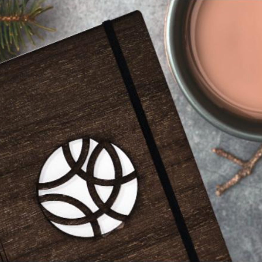 wooden journal resting beside cup of tea