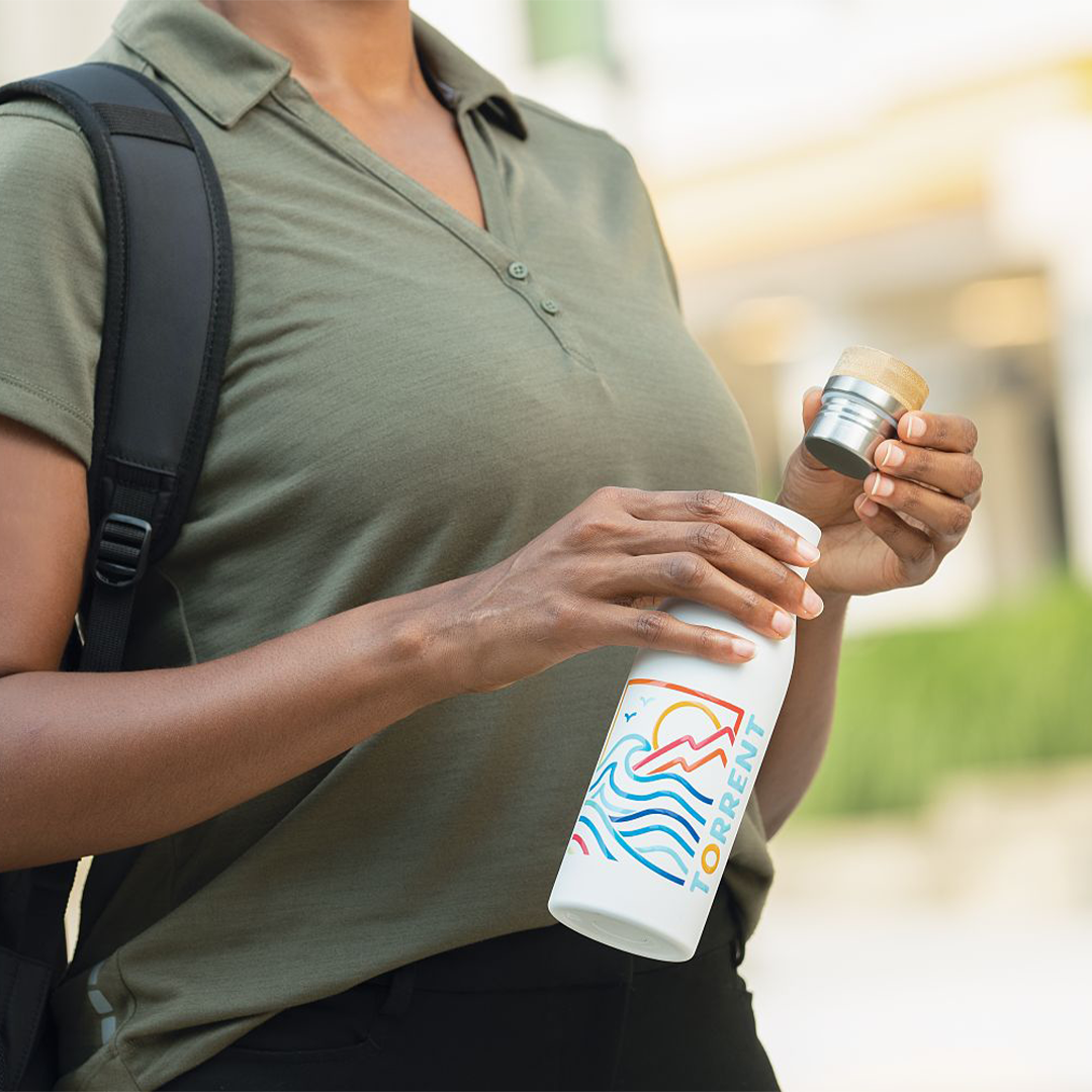 branded water bottle being held by woman in green shirt
